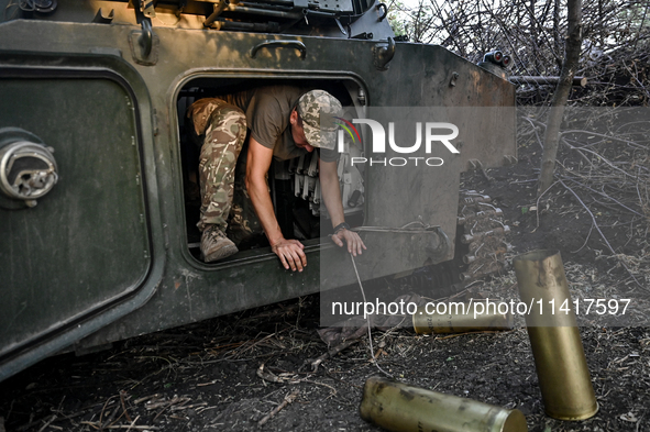 A serviceman of the 24th King Danylo Separate Mechanized Brigade is getting out of the cabin of a 122-mm howitzer D-30 during a combat missi...