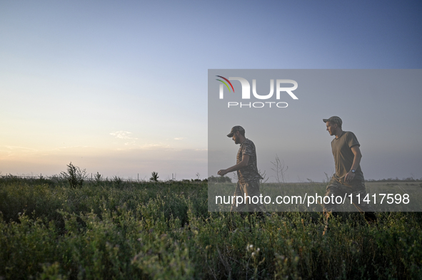 Servicemen of the 24th King Danylo Separate Mechanized Brigade are walking through a field during a combat mission near Chasiv Yar, Bakhmut...