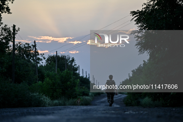 A serviceman of the 24th King Danylo Separate Mechanized Brigade is walking along a road in Bakhmut district, Donetsk region, eastern Ukrain...