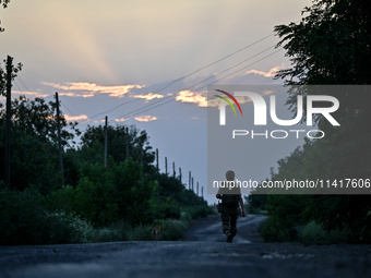 A serviceman of the 24th King Danylo Separate Mechanized Brigade is walking along a road in Bakhmut district, Donetsk region, eastern Ukrain...