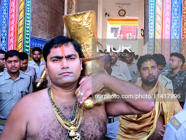 Temple servitors are carrying gold ornaments of temple deities before making the golden dressed ceremony 'Suna Besha' atop their chariots be...