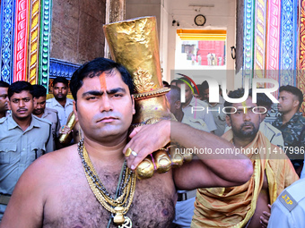 Temple servitors are carrying gold ornaments of temple deities before making the golden dressed ceremony 'Suna Besha' atop their chariots be...