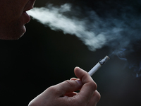 A person smokes a cigarette in Krakow, Poland on July 18, 2024. (