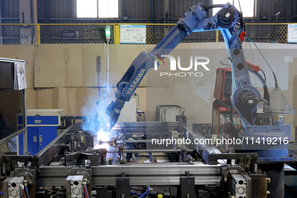 A robot is welding battery pack accessories for a new energy vehicle at an automated welding workshop of an intelligent manufacturing compan...