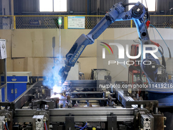 A robot is welding battery pack accessories for a new energy vehicle at an automated welding workshop of an intelligent manufacturing compan...