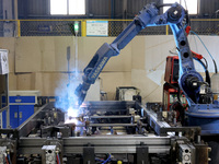 A robot is welding battery pack accessories for a new energy vehicle at an automated welding workshop of an intelligent manufacturing compan...