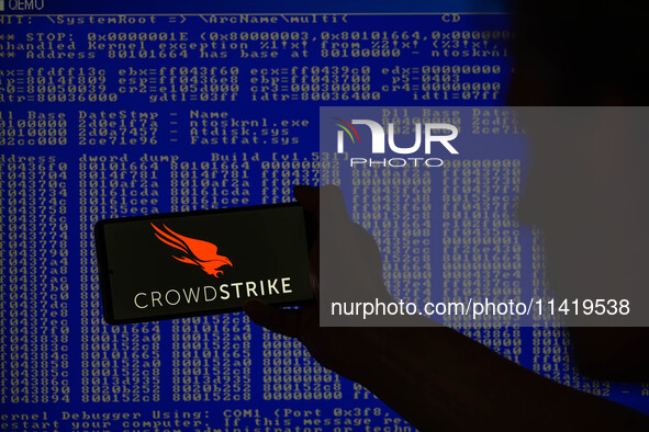 The CrowdStrike logo is being displayed on a smartphone with a Windows blue screen visible in the background in this photo illustration in B...