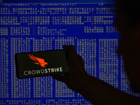 The CrowdStrike logo is being displayed on a smartphone with a Windows blue screen visible in the background in this photo illustration in B...