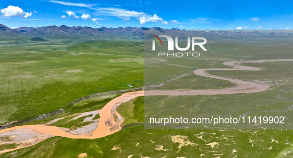 Reddish-brown water is meandering through a channel on the Tibetan Plateau in the upper reaches of Heihe River, China's second largest inlan...