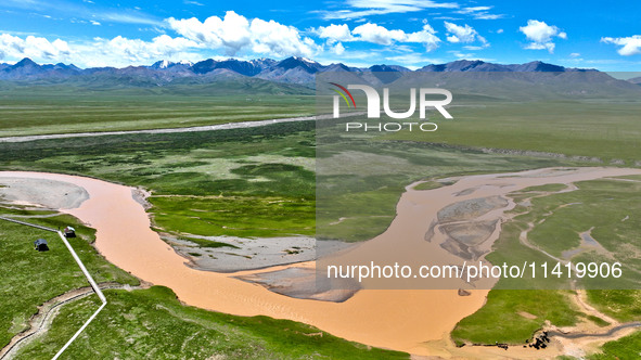 Reddish-brown water is meandering through a channel on the Tibetan Plateau in the upper reaches of Heihe River, China's second largest inlan...