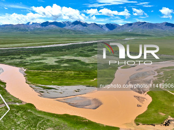 Reddish-brown water is meandering through a channel on the Tibetan Plateau in the upper reaches of Heihe River, China's second largest inlan...