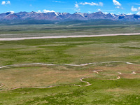 Reddish-brown water is meandering through a channel on the Tibetan Plateau in the upper reaches of Heihe River, China's second largest inlan...