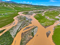 Reddish-brown water is meandering through a channel on the Tibetan Plateau in the upper reaches of Heihe River, China's second largest inlan...