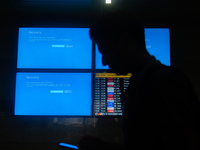 People are moving past screens displaying error messages amid a global Microsoft outage at the Indira Gandhi International (IGI) Airport, in...