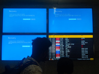 People are moving past screens displaying error messages amid a global Microsoft outage at the Indira Gandhi International (IGI) Airport, in...