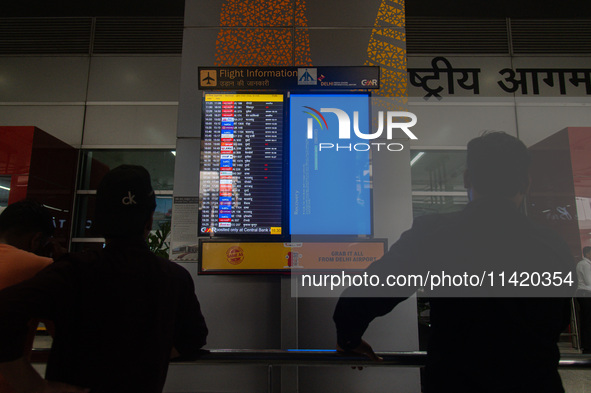 People are looking at the screen displaying an error message amid a global Microsoft outage at the Indira Gandhi International (IGI) Airport...