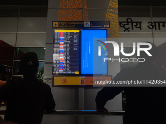 People are looking at the screen displaying an error message amid a global Microsoft outage at the Indira Gandhi International (IGI) Airport...