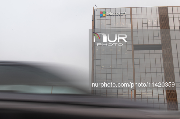 Vehicles are moving past an office building of Microsoft in Gurugram, on the outskirts of New Delhi, India, on July 19, 2024. Airlines, busi...