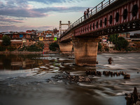 People are enjoying the cool breeze on the banks of the river Jhelum in Sopore, Jammu and Kashmir, India, on July 19, 2024. (