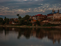 People are enjoying the cool breeze on the banks of the river Jhelum in Sopore, Jammu and Kashmir, India, on July 19, 2024. (