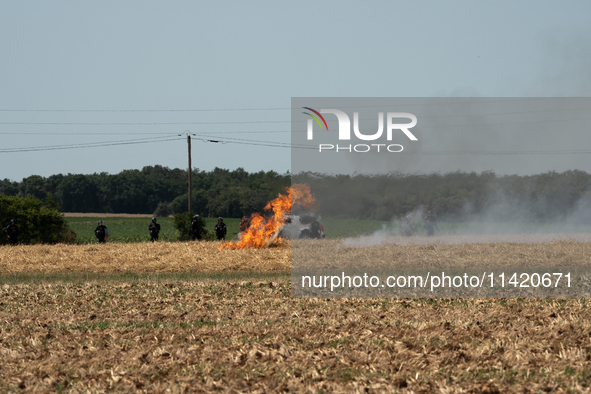 French Gendarmerie vehicles are stationing near a wildfire started by a launched tear gas canister during a march as part of a rally against...