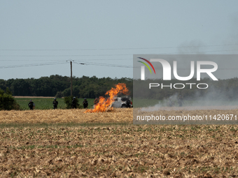 French Gendarmerie vehicles are stationing near a wildfire started by a launched tear gas canister during a march as part of a rally against...