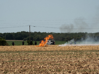 French Gendarmerie vehicles are stationing near a wildfire started by a launched tear gas canister during a march as part of a rally against...