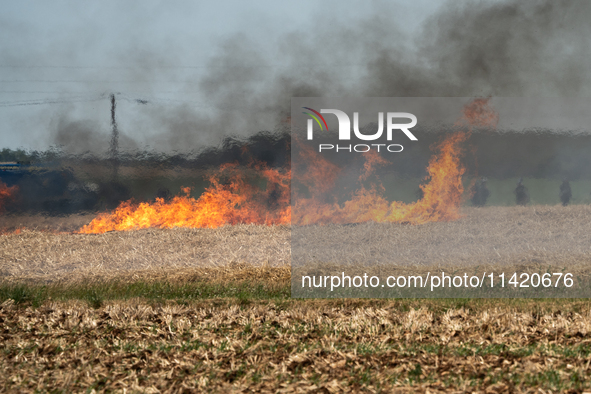 French Gendarmerie vehicles are stationing near a wildfire started by a launched tear gas canister during a march as part of a rally against...