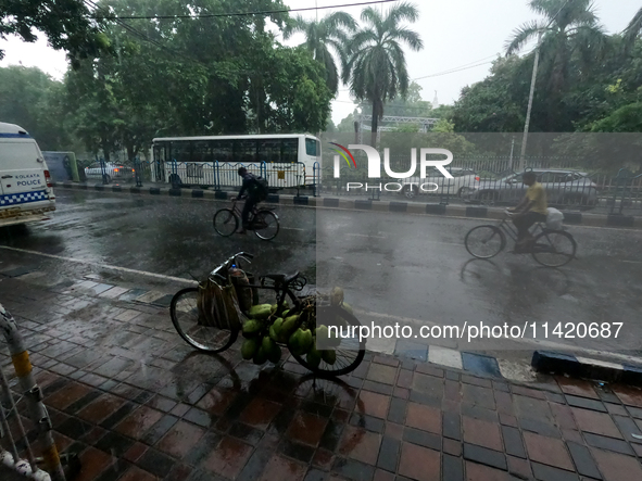 People are arriving in rain showers in Kolkata, India, on July 19, 2024. 