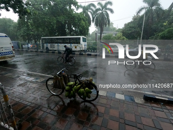 People are arriving in rain showers in Kolkata, India, on July 19, 2024. (