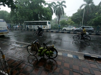 People are arriving in rain showers in Kolkata, India, on July 19, 2024. (