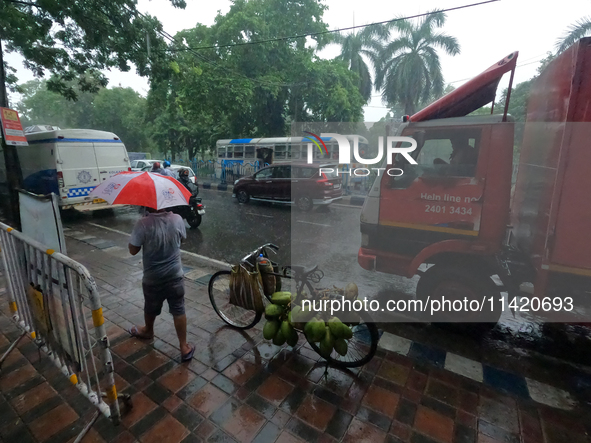 People are arriving in rain showers in Kolkata, India, on July 19, 2024. 