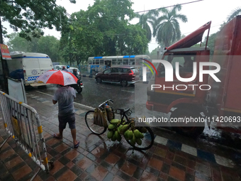 People are arriving in rain showers in Kolkata, India, on July 19, 2024. (