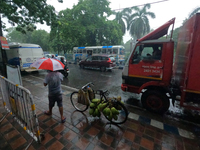 People are arriving in rain showers in Kolkata, India, on July 19, 2024. (