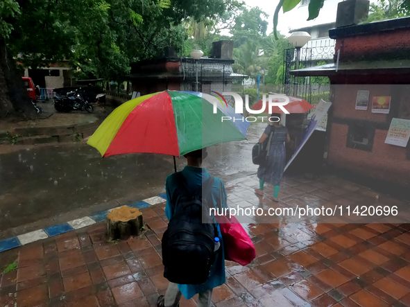 People are arriving in rain showers in Kolkata, India, on July 19, 2024. 