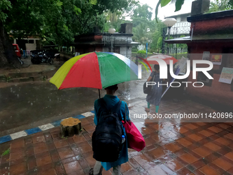 People are arriving in rain showers in Kolkata, India, on July 19, 2024. (