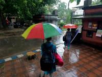 People are arriving in rain showers in Kolkata, India, on July 19, 2024. (