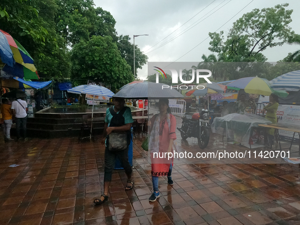 People are arriving in rain showers in Kolkata, India, on July 19, 2024. 