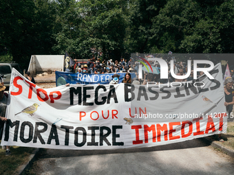 Demonstrators are holding a placard reading ''Stop the mega-basines for an immediate moratorium'' during a march as part of a rally against...