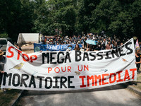 Demonstrators are holding a placard reading ''Stop the mega-basines for an immediate moratorium'' during a march as part of a rally against...