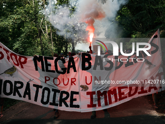 Demonstrators are holding a placard reading ''Stop the mega-basines for an immediate moratorium'' during a march as part of a rally against...