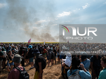 Protesters are walking past a wildfire started by a launched tear gas canister during a march as part of a rally against the construction of...