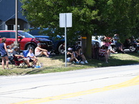 Bystanders are gathering to watch the funeral procession. Bystanders are gathering for the funeral procession of Corey Comperatore in Sarver...