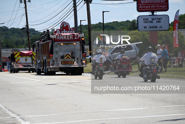 Fire trucks are at the funeral procession. Bystanders are gathering for the funeral procession of Corey Comperatore in Sarver, Pennsylvania,...