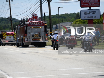 Fire trucks are at the funeral procession. Bystanders are gathering for the funeral procession of Corey Comperatore in Sarver, Pennsylvania,...