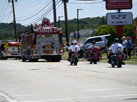 Fire trucks are at the funeral procession. Bystanders are gathering for the funeral procession of Corey Comperatore in Sarver, Pennsylvania,...