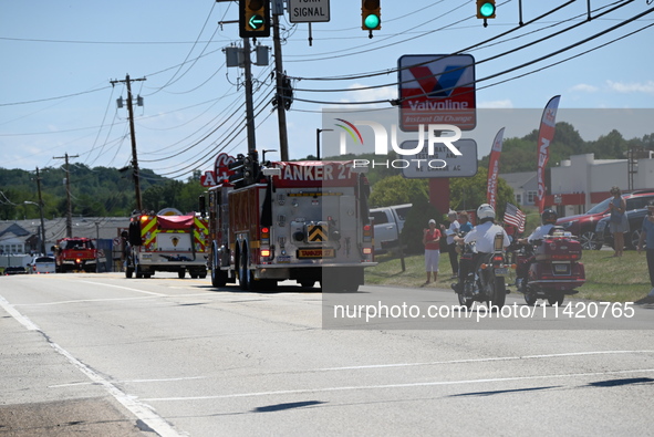 Fire trucks are at the funeral procession. Bystanders are gathering for the funeral procession of Corey Comperatore in Sarver, Pennsylvania,...