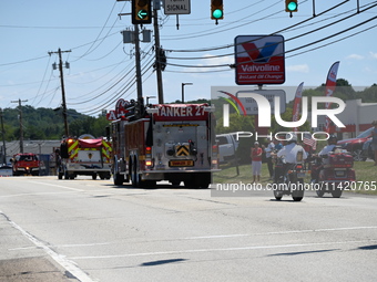 Fire trucks are at the funeral procession. Bystanders are gathering for the funeral procession of Corey Comperatore in Sarver, Pennsylvania,...