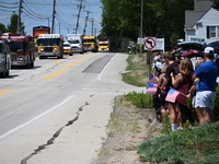 Bystanders are gathering and holding up signs and American flags for the funeral procession of Corey Comperatore in Sarver, Pennsylvania, Un...