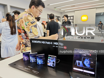 The Mi MIX Flip and MIX Fold 4 foldable phones are being displayed at the Xiaomi store in Tongling, China, on July 19, 2024. (